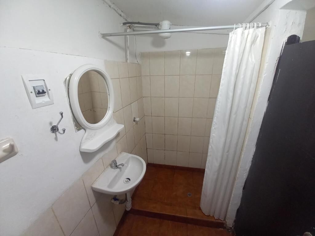 A small bathroom with a toilet, sink, and shower.