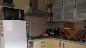 Une cuisine équipée d’un four à micro-ondes, d’une machine à café et de placards.