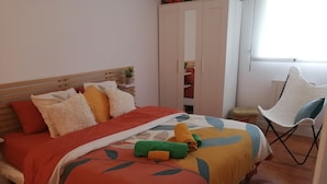 Une chambre à coucher avec un lit, une chaise, une armoire et une fenêtre.
