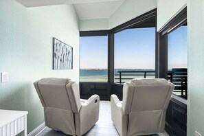 A balcony with two reclining chairs, a white table, and a framed artwork. - 🏝️Sound-Front | Two Balconies | Steps to the Beach | Palm Beach Club #206🏝️ (Pensacola Beach)