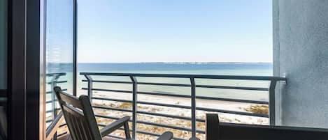Ein Balkon mit Meerblick, einem Stuhl und einem Tisch.