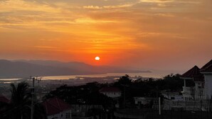 A sunset over a residential area with houses and a distant view of a body of water. - Golden Eagle/ jacuzzi/WIFI/ 20 min Airport & Beach (Montego Bay)