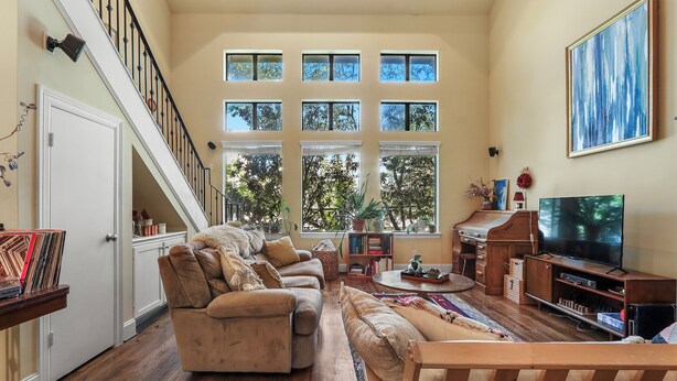 A spacious living room with a large sofa, a television, and a piano. - Cozy 3 bed 3 bath townhome with pool & hut tub.  Best location in Houston! (Houston)