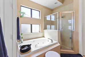 Un baño con bañera, ducha, inodoro y ventana.