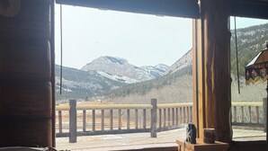 A wooden interior with a view of snow-covered mountains through a large window.