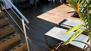 Una terraza en la azotea con zona de comedor, una escalera y vista al océano.