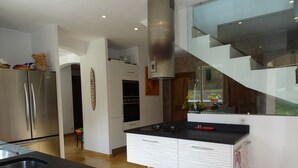 Una cocina moderna con electrodomésticos de acero inoxidable, una encimera negra y un lavamanos de acero inoxidable.