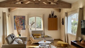Amplia sala de estar con techo alto, un sofá, una mesa de centro y un televisor.