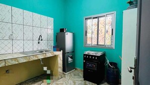 Una cocina pequeña con un lavabo, un refrigerador, una estufa y una ventana.