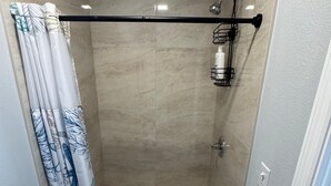 Ein kleines, modernes Badezimmer mit Dusche, Toilette und Waschbecken.