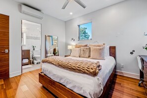 A bedroom with a bed, a ceiling fan, a window, and a bathroom visible through an open door. - Del Mar Retreat w/Ocean Views, Outdoor Pool, Rooftop Deck, Near Beaches & Trails (Del Mar)