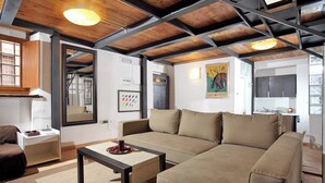 Una sala de estar moderna con un sofá, una mesa de centro y una cocina al fondo.