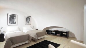 A bedroom with two beds, a bedside table, a nightstand, a bookshelf, and a black rug. - Manray Charming and Modern Ground Floor Loft (Rome)