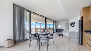 A modern interior with a dining area, a sofa, and a kitchen. - Mistiq Gardens 2 (Tulum)