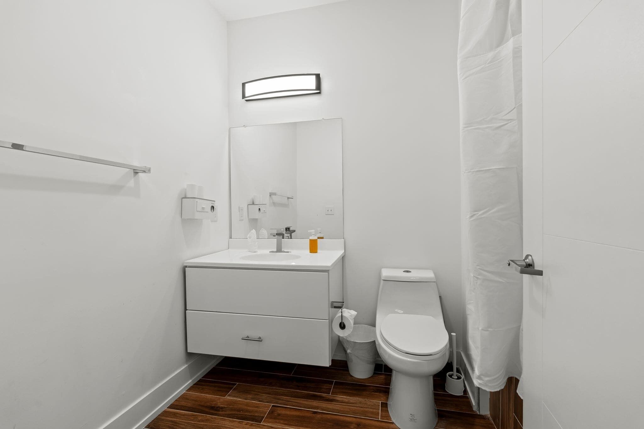 Ein modernes Badezimmer mit Waschbecken, Spiegel und Toilette.
