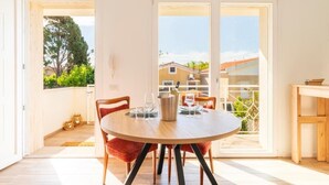 Un comedor con una mesa redonda, sillas y vistas al exterior por una puerta corrediza de vidrio.