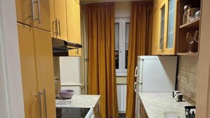 Una cocina compacta con armarios de madera, estufa y refrigerador.