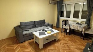 Una sala de estar con sofá, mesa de centro, comedor y sillas.