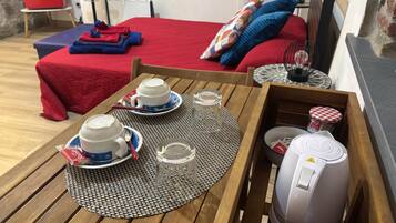 Una mesa de desayuno ordenada con dos tazas, un vaso y una tetera, sobre un mantel tejido.
