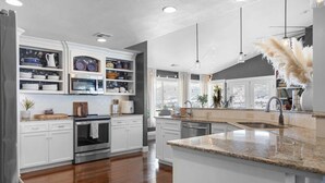 A modern kitchen with white cabinetry, a stainless steel oven, and a granite countertop. - Dream House - three bedroom, three in a half baths on Paschal Vineyard (Talent)