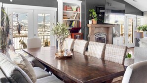 A dining area with a wooden table, wicker chairs, a bookshelf, and a fireplace. - Dream House - three bedroom, three in a half baths on Paschal Vineyard (Talent)