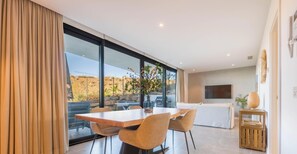 Un comedor moderno con una mesa grande, sillas y vistas amplias a través de grandes ventanales.
