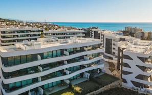 Ein modernes, mehrstöckiges Hotel mit Balkonen, großen Fenstern und Blick aufs Meer.
