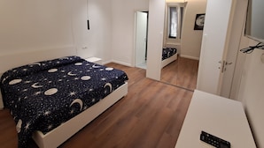 A bedroom with a bed, a wardrobe, a desk, and a mirror. - Pigneto new collection 1 (Rome)