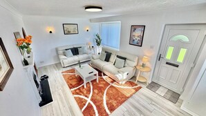 A living room with a sofa, coffee table, and a rug. - Modern 3 Bedroom Home | 4 Beds | Private Parking (Doncaster)