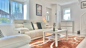 A living room with a sofa, a coffee table, and a rug. - Modern 3 Bedroom Home | 4 Beds | Private Parking (Doncaster)