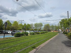 A parking lot with cars, a tram track, and a pedestrian path. - Le 28 : Studio - Terrace & Garden (Near Tram) (Valenciennes)