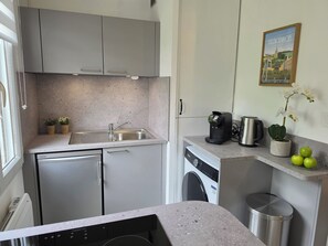 A compact kitchen with a dishwasher, sink, coffee maker, and a washing machine. - Le 28 : Studio - Terrace & Garden (Near Tram) (Valenciennes)