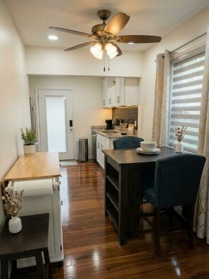 A compact kitchen with a dining area, a ceiling fan, and a window with blinds. - Charming House Retreat Near Charleston (Charleston)