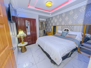 A bedroom with a bed, bedside tables, a wardrobe, and a mirror.