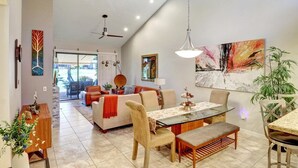 Un espacio habitable amplio con una mesa de comedor, sillas, un sofá y un ventilador de techo.