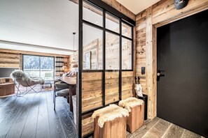 Ein modernes Interieur mit Holzvertäfelung, einem großen Fenster, einer Essecke und einer Tür.