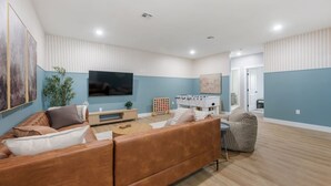 Un salon moderne avec un canapé, une table basse et une table de baby-foot.