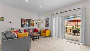 Una sala de estar moderna con un sofá gris, un sillón amarillo y un comedor con mesa y sillas.
