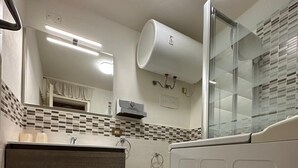 Un bany amb tocador, vàter, bidet i zona de dutxa.