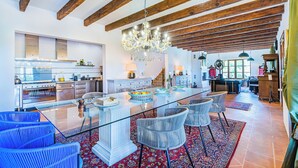A spacious kitchen with a central island, wooden beams, and a chandelier. - Mallorca Finca Aria vacation home a quiet paradise for family & friends (Búger)