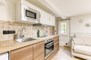 A modern kitchen with a microwave, double sink, and oven. - Peaceful 1-bedroom apartment in charming Joinville-le-Pont ACCES DISNEYLAND (Joinville-le-Pont)