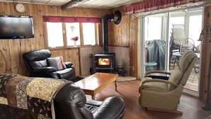 Un salón acogedor con chimenea, mobiliario de cuero y televisor.