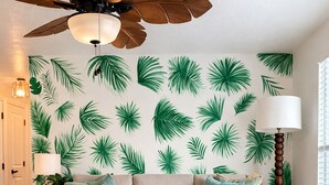Una sala de estar con sofá, una mesita redonda y un ventilador de techo.