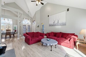 A spacious living room with a high ceiling, a dining area with natural light, and a large window. - Hot Tub*Sauna*Pool Table*Air Hockey*King Bed*Deck (Blakeslee)