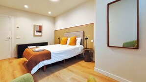 A hotel room with a bed, bedside table, lamp, and a mirror on the wall. - Apt. 1 br. Cathedral I, Historic Center (Valladolid)