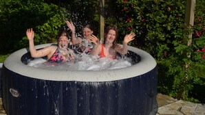 Un bain à remous où trois personnes se détendent dans l’eau.