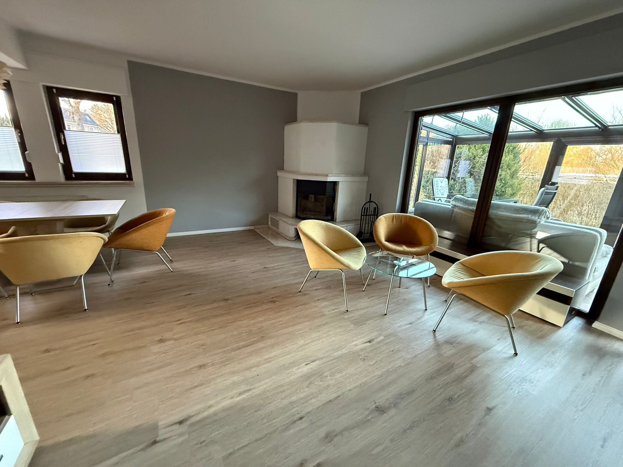 Ein modernes Wohnzimmer mit Kamin, großen Fenstern und zeitgenössischen Möbeln.