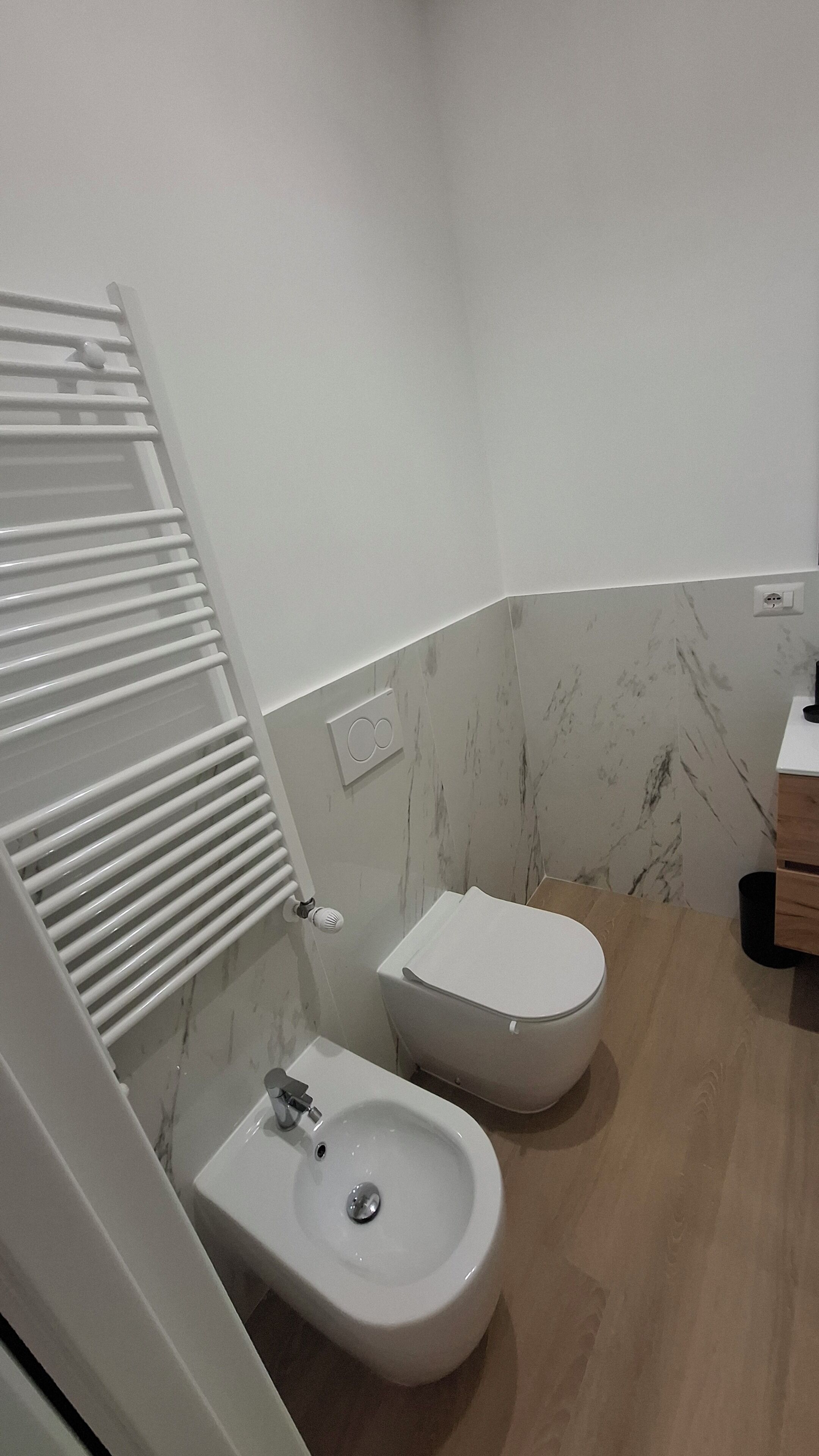 A bathroom with a bidet, a sink, and a toilet.