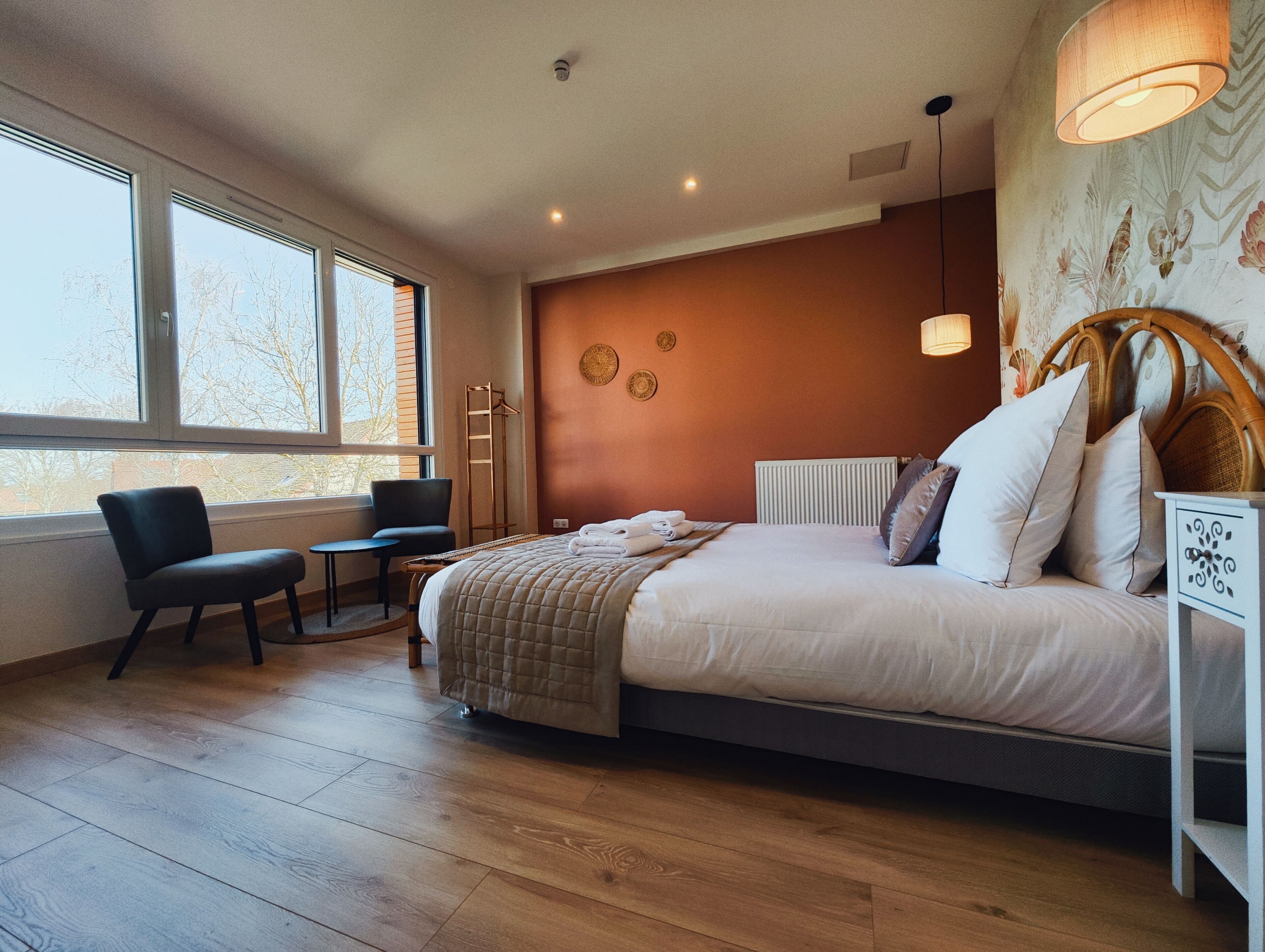 Une chambre à coucher comprenant un lit, une table de chevet, une chaise et une petite table.