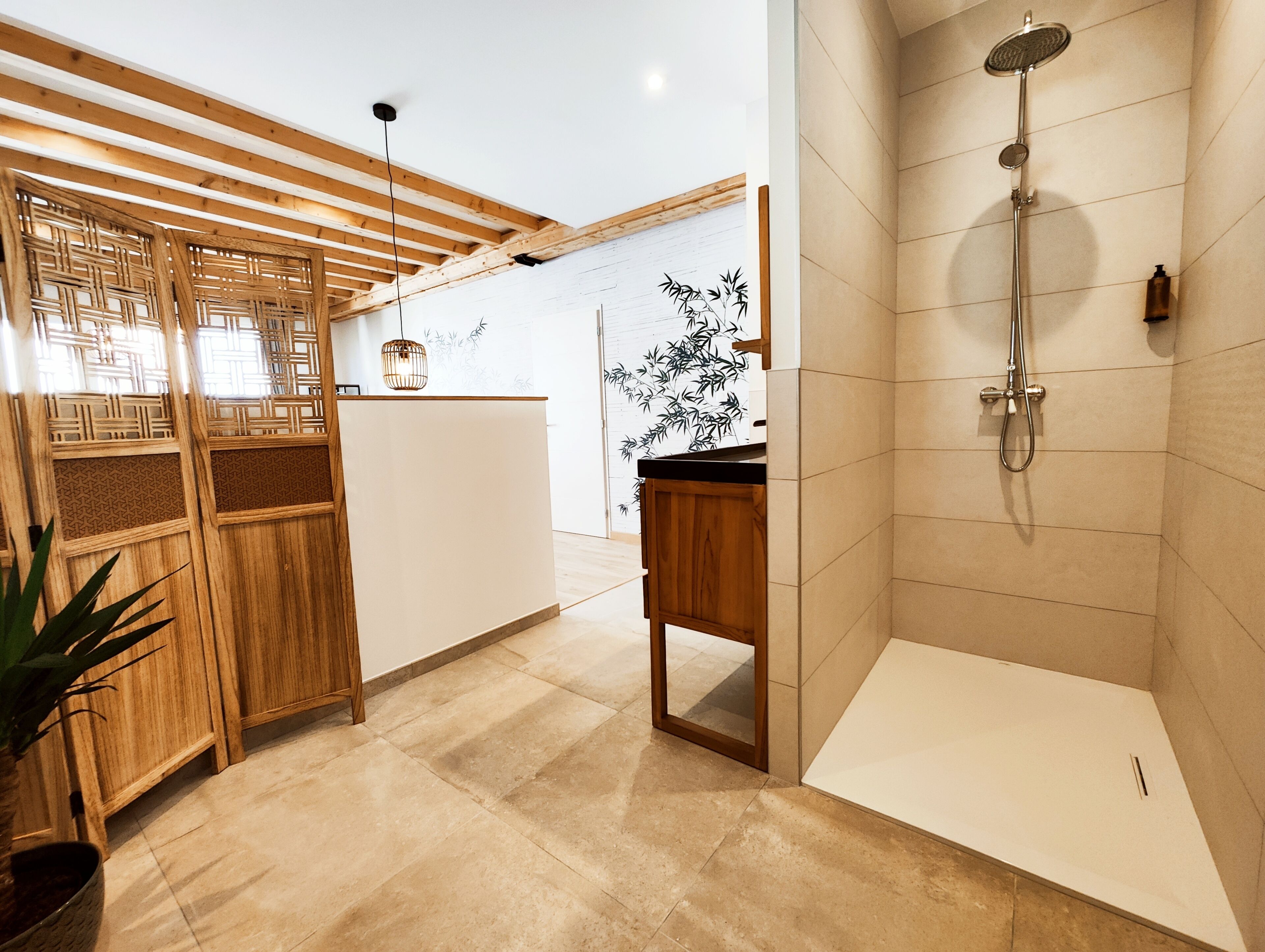 A modern bathroom with a shower, wooden paneling, and a potted plant.